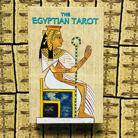 Egipto tarot kortų rinkinys su smėlio spalvos papiruso dėklu, priekyje sėdinčios faraonės iliustracija.