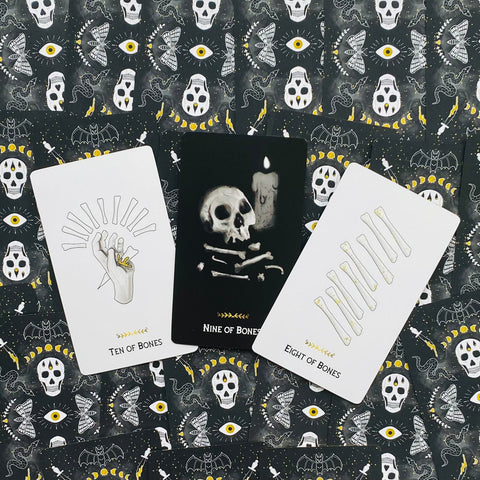 Tarot kortos trijų kortų išklotė — juodos ir baltos Bones kortos (Dešimt, Devynios, Aštuonios) ant ornamentuoto fono