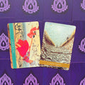 tarot kortos su dviem atvertais piešiniais: raudona „Anchor to Fly“ ir akmeninė „Desert Harvest“ ant violetinio fono