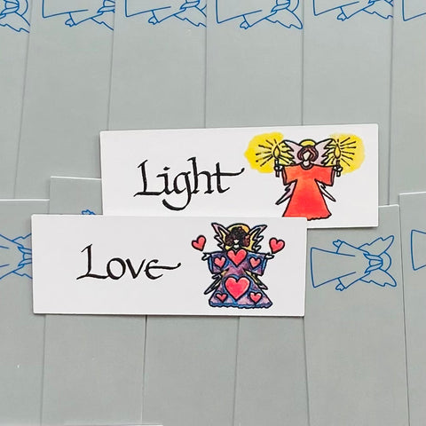 Dovanų etiketė su ranka pieštomis angelų iliustracijomis ir užrašais "Light" bei "Love", matomas priekinis dizainas