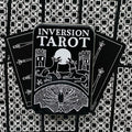 Tarot kortos Inversion juodai baltas rinkinys metalinėje dėžutėje, kortos išskleistos vėduoklė prieš geometrinį foną