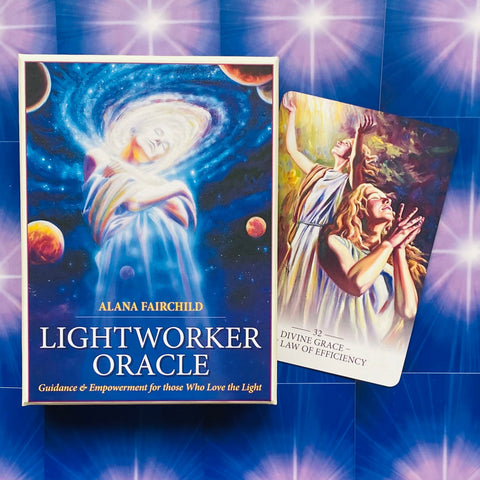 Lightworker Oracle kortos Alanos Fairchild mėlyna dėžutė su auksiniu užrašu ir viena atversta korta, rodanti dizainą