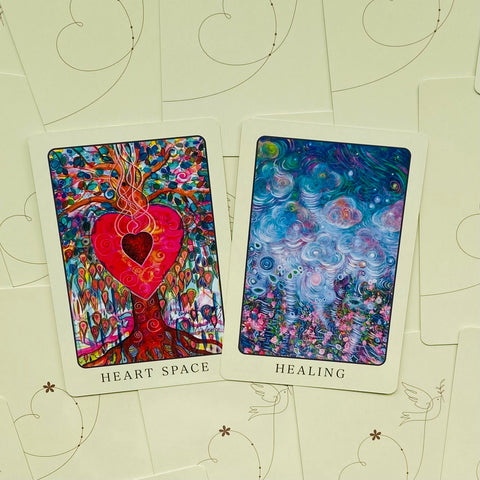 Orakulų kortos: ryškiai raudona Heart Space širdies medžio korta ir mėlyna Healing gijimo korta, išdėstytos ant kreminių nugarėlių iš viršaus