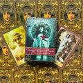 Vintage Wisdom Oracle kortų rinkinys (Victoria Moseley) — centrinė mėlyna pakuotė su dviem pavyzdiniais kortomis, auksinis ornamentuotas fone, kampinė perspektyva