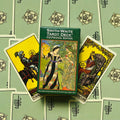 Smith‑Waite tarot kortos Centennial Edition žalia dėžutė centre, trys išskleistos pentaklių kortos fone