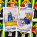 Tarot kortos Queen of Swords ir Prince of Swords, dvi priekinės kortos ant spalvingų nugarėlių — ryškūs simboliai ir violetinė fono gama