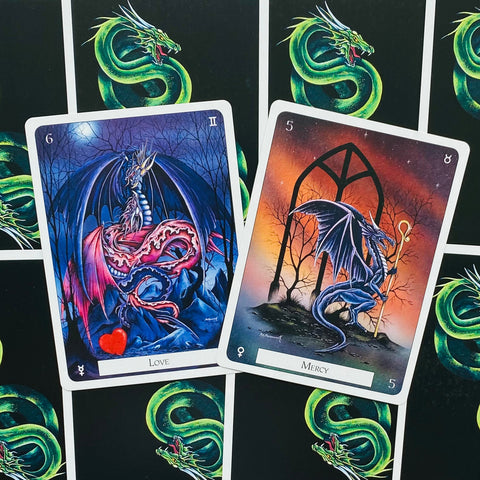 Tarot kortos su drakonų iliustracijomis — mėlyna „Love“ ir oranžinė „Mercy“ kortos parodytos iš arti, akcentuojant meninį dizainą