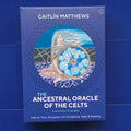 Ancestral Oracle kortų rinkinys tamsiai mėlynoje dėžutėje, aut. Caitlín Matthews, viršuje iliustracija sėdinčios moters su spiraliniu ratu, skirtas protėvių vadovavimui ir gydymui