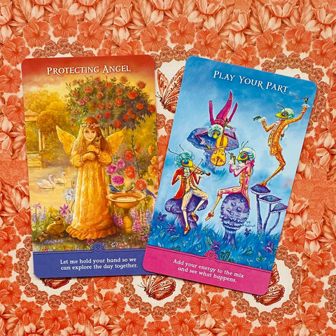 Kortos orakuliui: dvi spalvingos kortos — geltonai oranžinė „Apsauginis angelas“ ir melsva „Įsitrauk“, ant raudonų gėlių fono