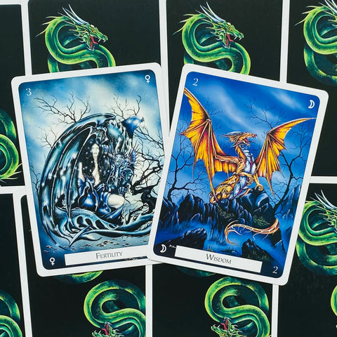 tarot kortos su žaliu drakono nugarėlių dizainu, dvi atviros mėlynos tematikos kortos „Fertility“ ir „Wisdom“ rodytos iš arti
