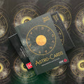 Astrologinės kortos Astro‑Cards (Tanja Brock) tamsiai žalia dėžutė su auksiniu zodiako ratu ir bukletu, fotografuota iš viršaus