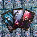 tarot kortos trijų kortų išklotinė su tamsiomis gotikinėmis iliustracijomis ant ornamentuoto kortų nugarėlių