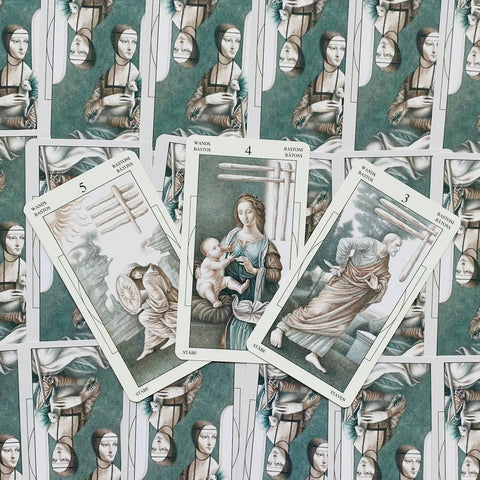 tarot kortos Renesanso stiliaus rinkinys, trys atverstos kortos (3, 4, 5 lazdos) centre ant žalsvų nugarėlių fono