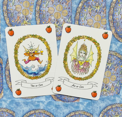 tarot kortos su taurėmis: pateikiamos Ace of Cups ir Two of Cups prie mėlyno ornamentuoto fono, plokščias kampas
