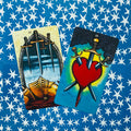 Tarot kortos Rider–Waite, dvi atverstos kortos (Trys kardai, Keturi kardai) ant mėlyno žvaigždėto fono, artimas kampas