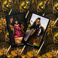 Tarot kortos su Karaliaus ir Karalienės Lazdų iliustracijomis ant auksinės mechaninių ratų nugarėlės, horizontalia kompozicija pabrėžia dizaino variantą