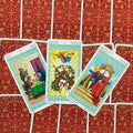 Tarot kortos Rider–Waite stiliaus žaliu rėmeliu, trijų kortų išdėstymas su Ace of Wands centre ant raudono nugarėlių rašto
