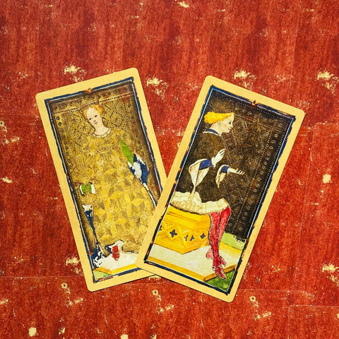 Tarot kortos — senovinio stiliaus iliustracijos, dvi priekinės figūros persidengiančios kampu ant raudono tekstūrinio fono