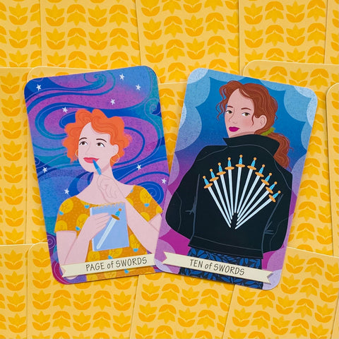 tarot kortos su Page of Swords ir Ten of Swords iliustracijomis, ryškios spalvos prie geltonų raštuotų kortų nugarėlių
