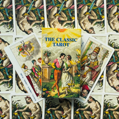 Tarot kortos The Classic — dėžutė priekyje su pora atvertų kortų ant fanuotos kortų fono