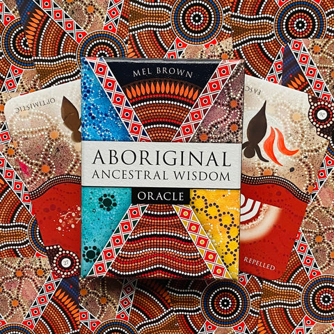 Aboriginal oracle kortos Mel Brown, spalvota dėžutė centre ir išdėliotos kortos su aborigenų taškiniais raštais, artimas planas