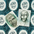 Kortos su meniškomis juodai baltomis iliustracijomis, dvi atverstos kortos parodo skirtingus veido motyvus ir spiralinius raštus