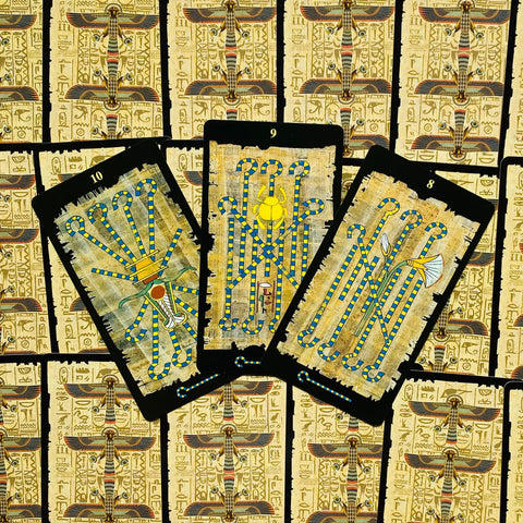 Tarot kortos egiptietišku dizainu, trys atverstos lazdelės (10, 9, 8) išdėstytos ant aukso papiruso fono