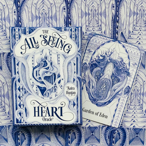 Orakulo kortos The All Seeing Heart (Saira Hunjan) mėlynos‑baltos dėžutės priekinis viršelis ir atvira "Garden of Eden" korta