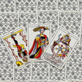 Tarot kortos Marseille stiliaus: trys didžiosios arkana kortos (Force XI, Roue de Fortune, Le Pendu) ant ornamentuoto nugarėlio