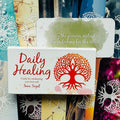 Daily Healing kortų rinkinys, balta dėžutė su ryškiu raudonu medžio logotipu ir žalia citata viršuje