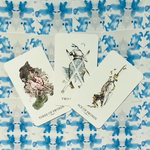 tarot kortos – minimalistinis kardų kostiumas (Ace, Two, Three) ant mėlynos raštuotos nugarėlės, trijų kortų išdėstymas