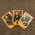 Tarot kortos rinkinys su trijų kortų vėduokle: bordo rėmeliai, viduramžių stiliaus iliustracijos, matoma iš viršaus