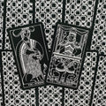 tarot kortos juodai baltos, atverstos „Strength“ ir „The Chariot“ kortos dėmesį traukiančiame juodai baltame geometriniame fone
