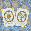 Tarot kortos, dvi iliustruotos kortos (Porter of Platters ir Ten of Platters) ant mėlyno raštuoto fono, pynės vainikai ir kriaušių ikonėlės