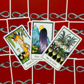 Tarot kortos Rider–Waite stiliaus – atverstos 4, 5 ir 6 taurės kortos išdėstytos ant raudonų nugarėlių su gyvatės raštu