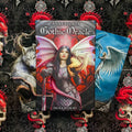 Gothic Oracle kortų rinkinys Anne Stokes — dėžutė su knygele centre, juoda ir raudona gotikinė estetika bei dvi iliustruotos kortos šonuose