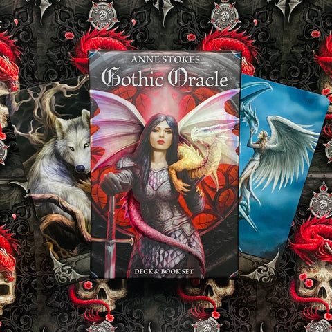 Gothic Oracle kortų rinkinys Anne Stokes — dėžutė su knygele centre, juoda ir raudona gotikinė estetika bei dvi iliustruotos kortos šonuose