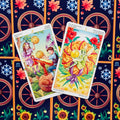 Tarot kortos su spalvingais Pentaklių motyvais — dvi atviros kortos (2 Pentakliai ir Tūzas) ant tamsios nugarėlės rašto