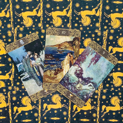 Tarot kortos trijų kortų išklotinė su ornamentuotais auksiniais kraštais ant mėlyno‑geltono fono su geltonais žirgais ir saulėmis, iliustraciniai meniniai paveikslai