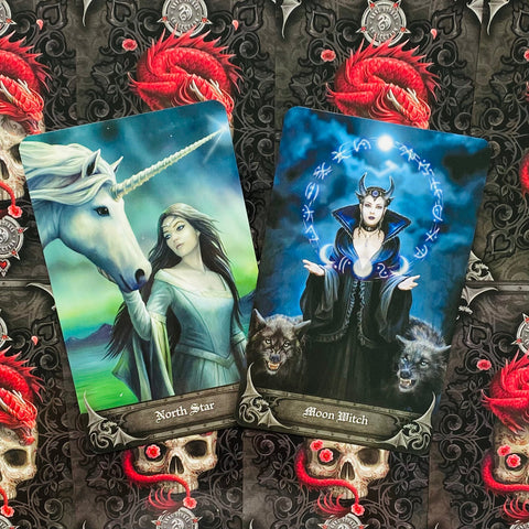 Tarot kortos su atverstos kortos North Star ir Moon Witch, melsvai–žali tonai ant tamsaus kaukolių fono