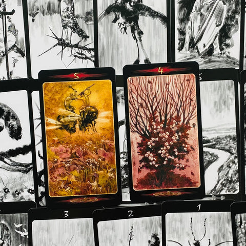 tarot kortos su dviem atvertais motyvais — auksinė bičių scena kairėje ir rausvas žydintis medis dešinėje