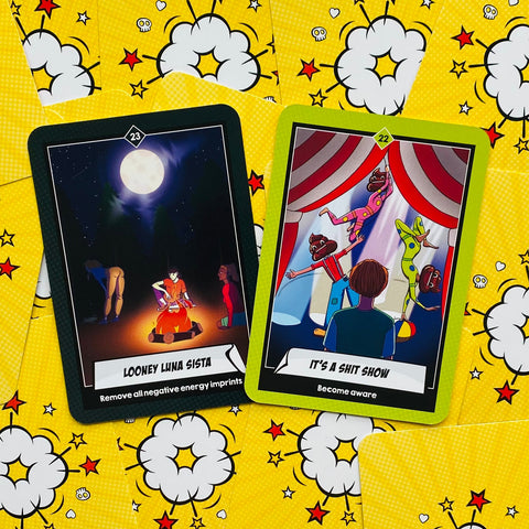 tarot kortos su geltonu komiksiniu nugarėliu, dvi atidengtos kortos: mėnulio apeigos ir cirko scenos kortos