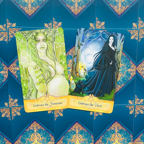 Orakulų kortos, artimas priekinis planas su dviem pavyzdinėmis kortomis: žalia Embrace the Feminine ir juoda Embrace the Dark, parodytas dizaino variantas