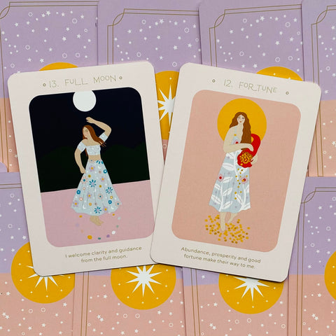 tarot kortos pasteliniame dėkle, arti fotografuotos dvi kortos Full Moon ir Fortune su afirmacijomis