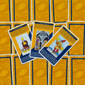 tarot kortos Rider‑Waite stiliaus geltonai mėlynais nugarėliais, trijų Pentaklų kortų išklotinė centre, kampu uždėtos