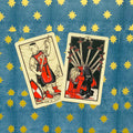 Tarot kortos Rider‑Waite stiliaus: dvi kortos — Page of Swords ir Ten of Swords ant mėlyno žvaigždėto fono, fotografuota iš viršaus
