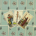 Tarot kortos Rider Waite su šviesiai mėlynomis nugarėlėmis, trijų kortų išdėstymas iš arti, kortos įstrižai