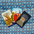 Tarot kortos komplektas su trimis atverstomis kortomis (Dešimt lazdų, Devynios pentaklės, Devynios kardai) ant mėlyno gėlių fono, pasvirusiu išdėstymu