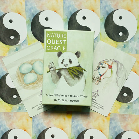 orakulo kortos Nature Quest žalioje dėžutėje su pandos piešiniu centre, dvi atverstos kortos iš šonų ir pastelinis jin‑jan fonas