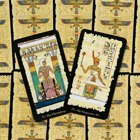 tarot kortos egiptietišku dizainu, dvi atviros kortos (V. Hierophantas, IV. Imperatorius) ant auksinių hieroglifų nugarėlių